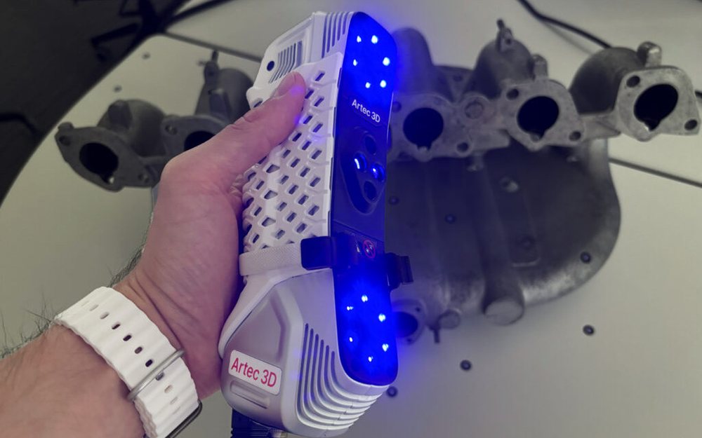 An Artec Point II laser 3D scanner scanning a targeted intake manifold