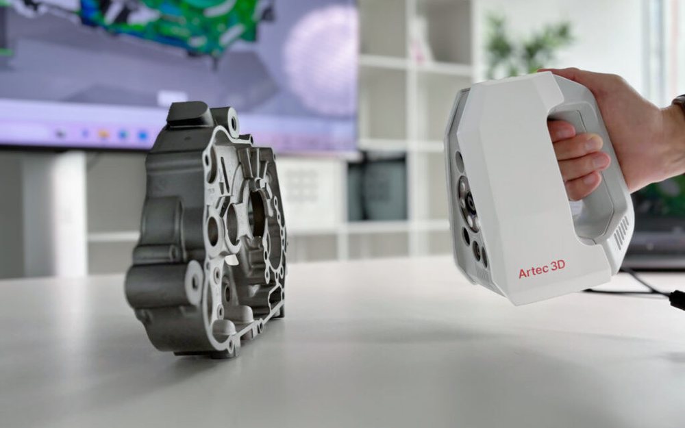 An Artec Spider II 3D scanner in hand, scanning a cast engine housing