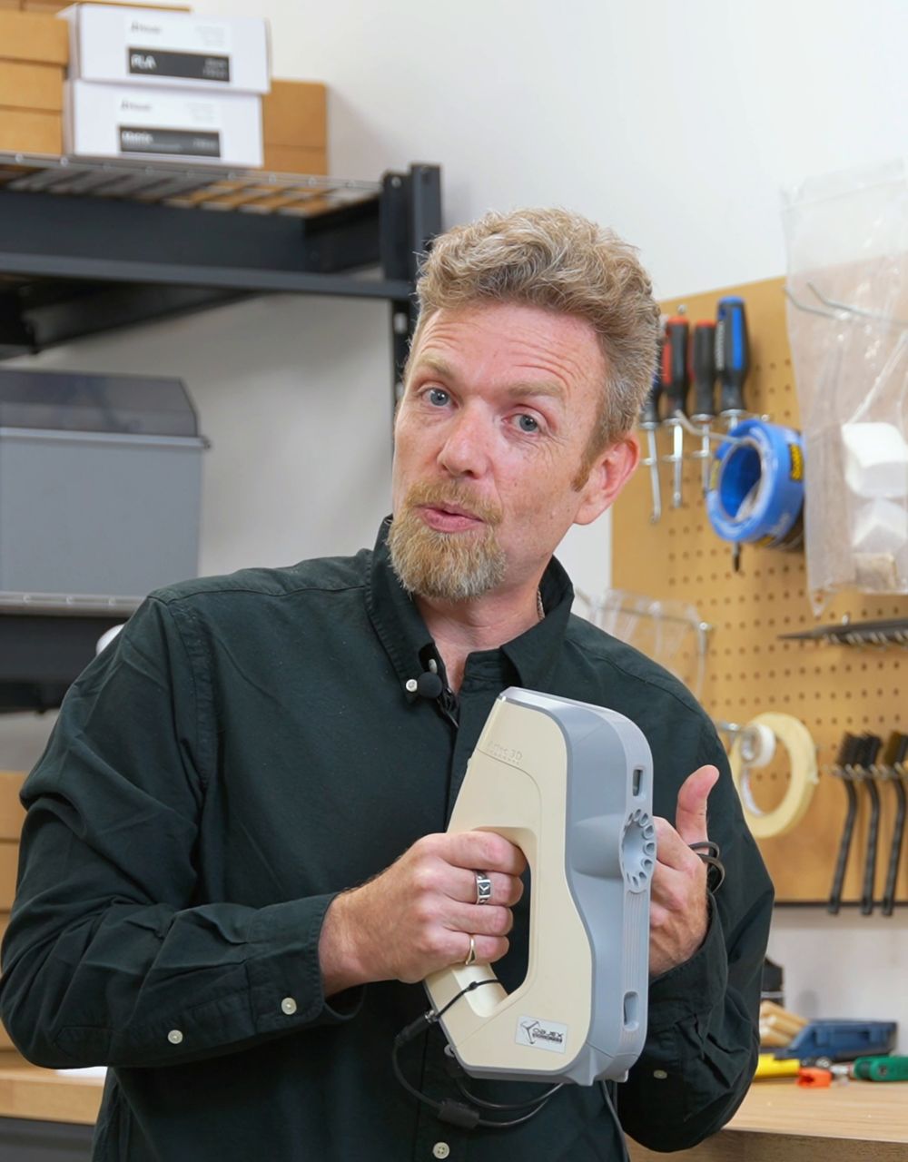Steve Cory holding an Artec Eva 3D scanner in the workshop